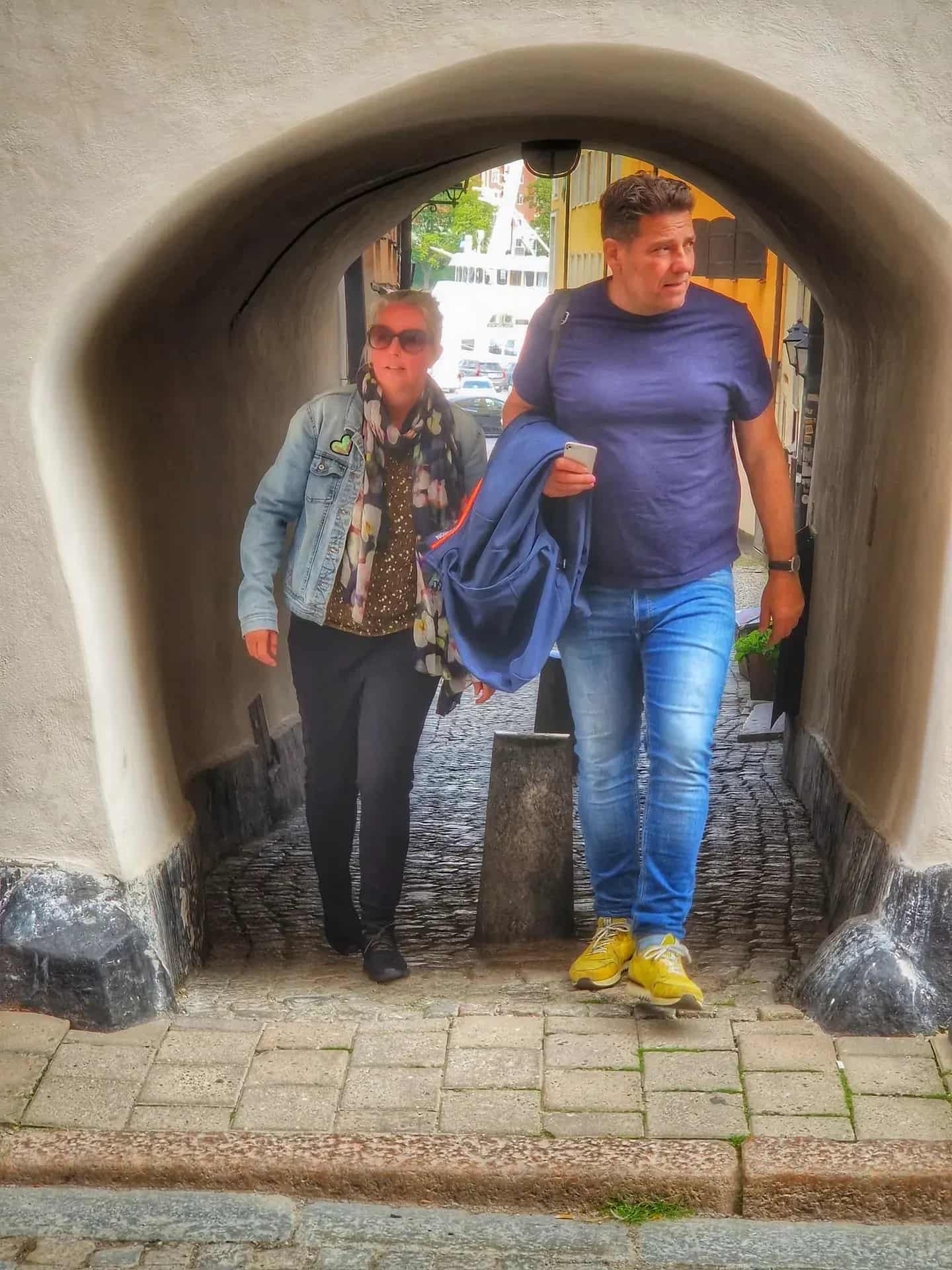 Two people walk through a tunnel