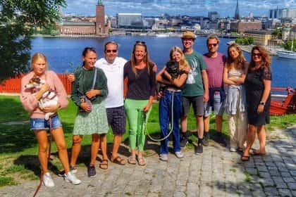 Grupp med åtta personer och två hundar framför Stockholms stadshus